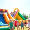 Kids enjoying a Slide rental on a sunny day, creating a joyful atmosphere at an outdoor party.