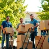 Movers from a removal company east london efficiently packing and moving boxes in a residential area