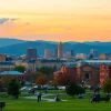 Clarksburg skyline illuminated at sunset with vibrant colors and people enjoying the park.