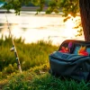 Showcase a functional fly fishing bag filled with vibrant lures beside a river, perfect for anglers.