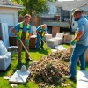 Efficient junk removal service team clearing yard debris and unwanted items in a clean residential area.