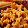 Enjoying Bhujia snacks served in a decorative bowl, showcasing their crispy texture and vibrant color.