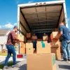 Efficient team providing Local Moving Services with boxes and a truck in a sunny neighborhood.