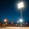 Enhance visibility with a battery tower light during dusk on a construction site.