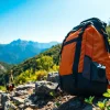 Wasserdichter Rucksack auf einem Bergpfad mit robustem Design und lebhaften Farben.