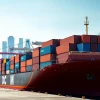 Showcasing imports with a cargo ship unloading goods at a vibrant international trade port.