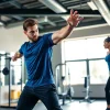 Personal trainer tunbridge wells guiding a client through an exercise in a vibrant gym setting.