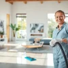 Bond cleaning professional ensuring flawless surfaces in a bright living room setting.
