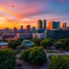 Stunning skyline view of Greensboro NC at sunset with vibrant city lights reflecting off buildings.