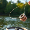 Angler casting Fly fishing line into a tranquil lake surrounded by lush greenery.